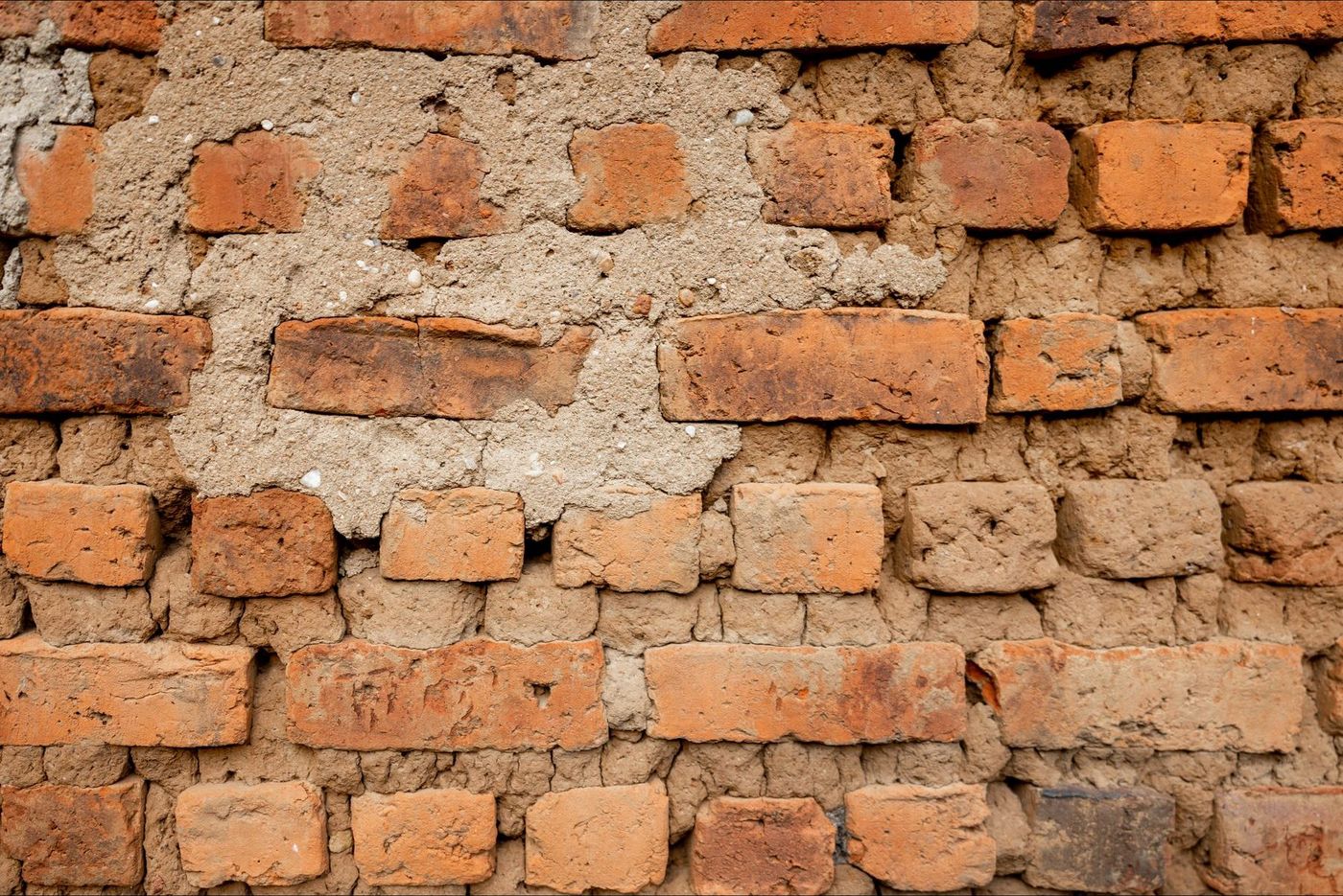 Oude bakstenen muur van dichtbij, met voegen en verweerde stenen